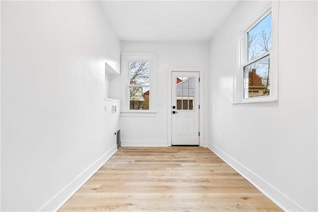 doorway to outside with a wealth of natural light and light wood-type flooring