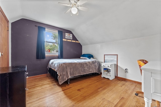 bedroom with ceiling fan, vaulted ceiling, and light hardwood / wood-style floors