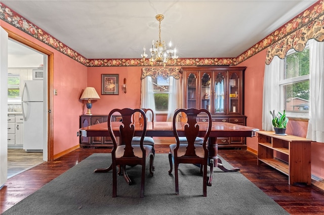 dining area with a notable chandelier, dark hardwood / wood-style floors, and a wealth of natural light