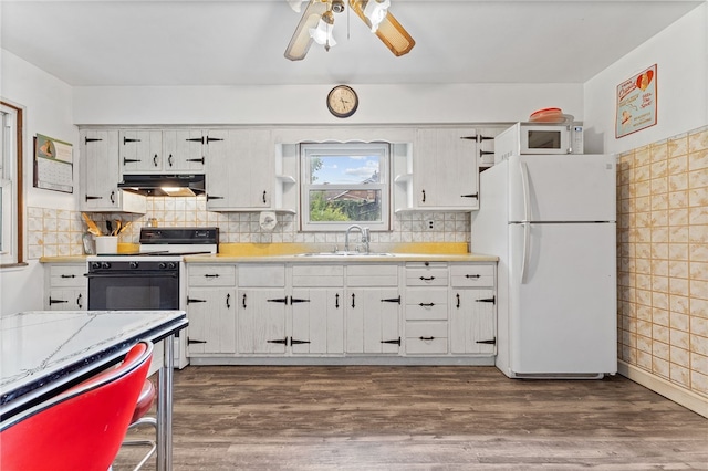 kitchen with dark hardwood / wood-style flooring, white appliances, ceiling fan, and sink