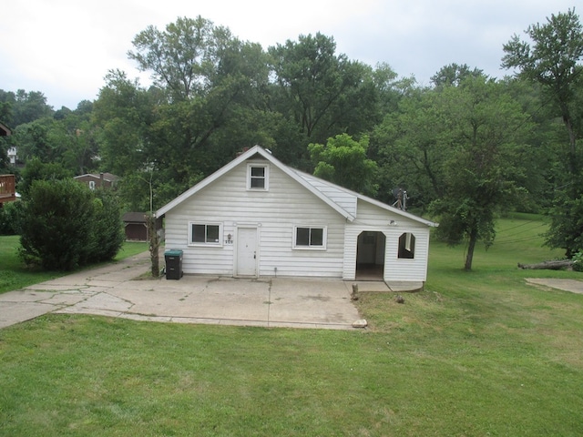 back of house with a patio area and a lawn