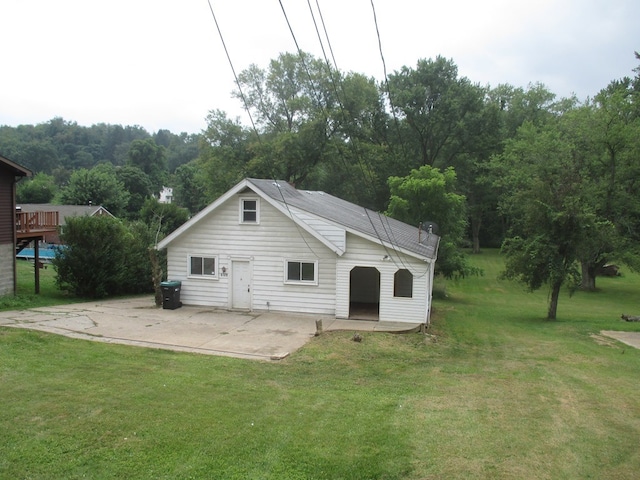 rear view of property with a patio and a lawn