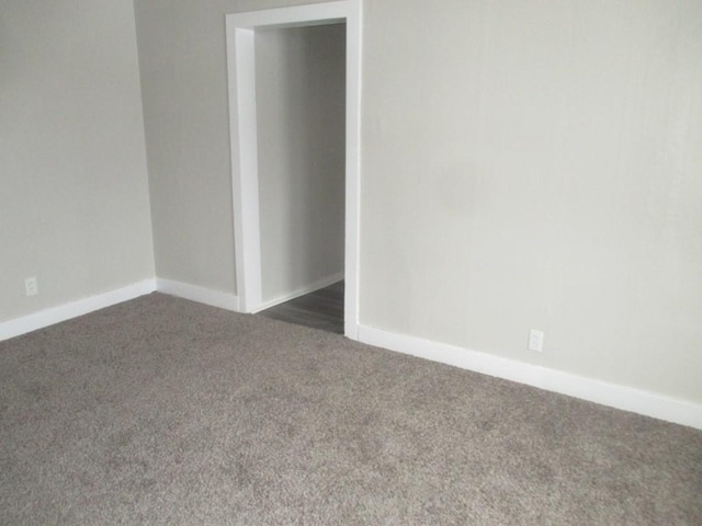 spare room featuring dark colored carpet