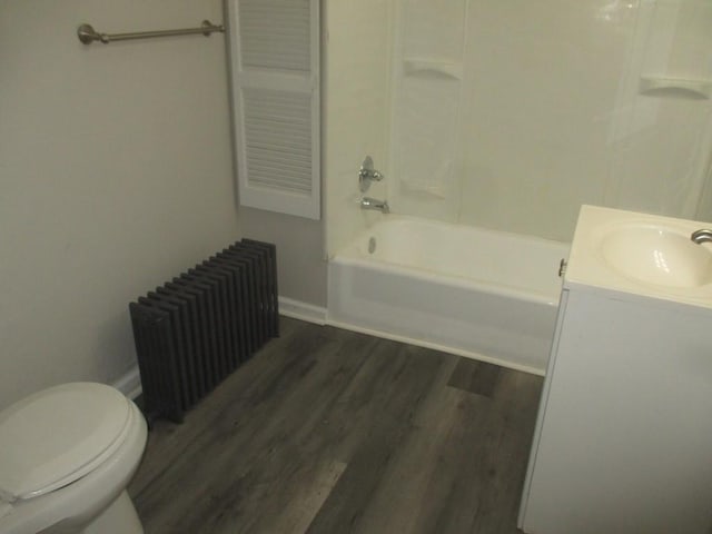 full bathroom with radiator heating unit, tub / shower combination, wood-type flooring, toilet, and vanity