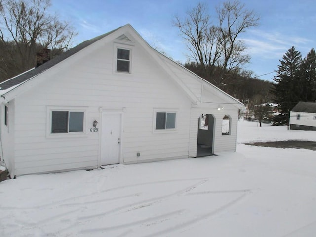 view of snow covered rear of property