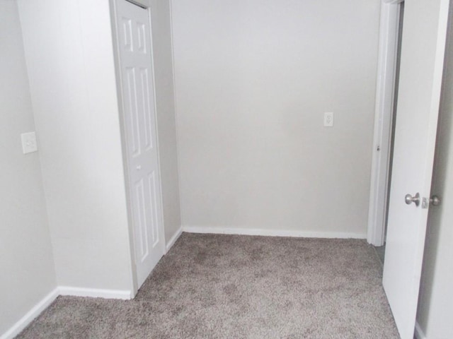 unfurnished room with light carpet and baseboards