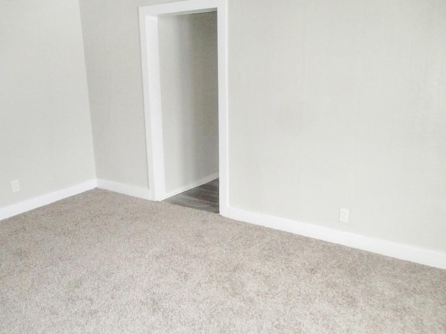 empty room featuring carpet and baseboards