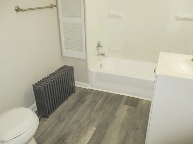 full bathroom featuring shower / bathtub combination, toilet, wood finished floors, vanity, and radiator