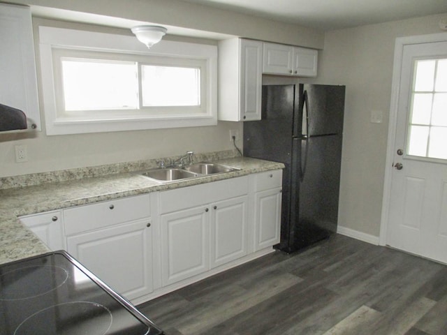 kitchen with dark wood finished floors, freestanding refrigerator, light countertops, white cabinetry, and a sink