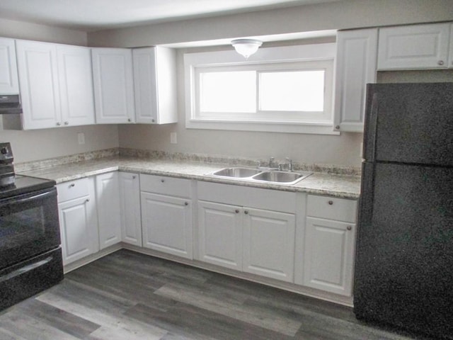 kitchen featuring dark wood-type flooring, light countertops, black appliances, white cabinetry, and a sink