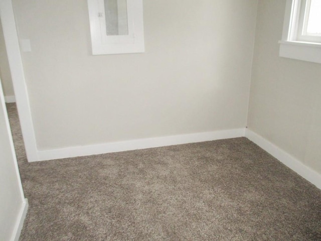 carpeted spare room featuring baseboards