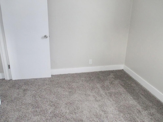 carpeted spare room with baseboards