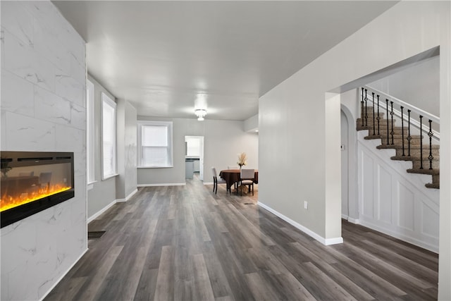 unfurnished living room featuring a premium fireplace and dark hardwood / wood-style flooring