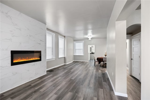 unfurnished living room featuring dark hardwood / wood-style flooring and a tile fireplace