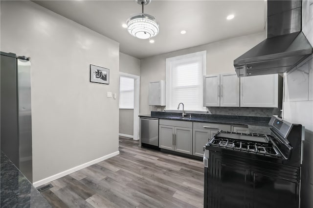 kitchen with sink, wall chimney range hood, dishwasher, black range with gas stovetop, and light hardwood / wood-style floors