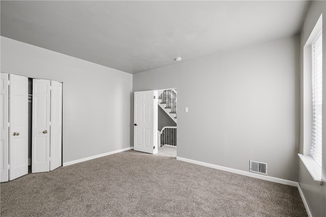 unfurnished bedroom featuring carpet and a closet