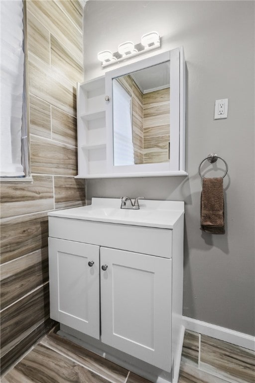 bathroom with vanity, wood walls, and hardwood / wood-style floors