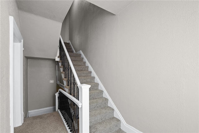 stairs featuring carpet and vaulted ceiling