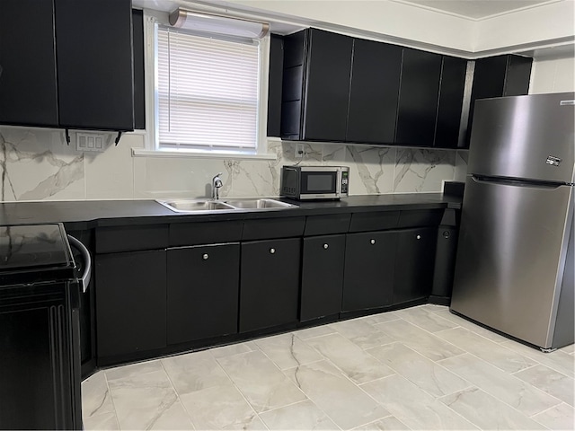 kitchen featuring appliances with stainless steel finishes, decorative backsplash, and sink