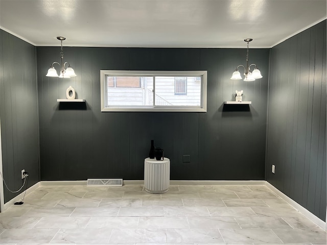 empty room with wooden walls, an inviting chandelier, and a wealth of natural light