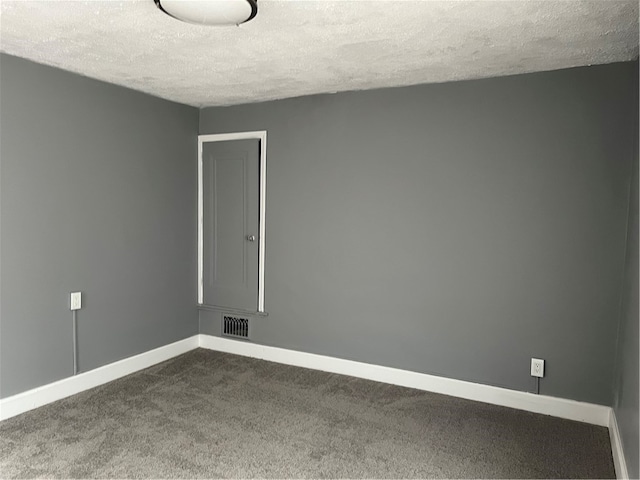 carpeted empty room with a textured ceiling