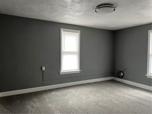 carpeted spare room with a textured ceiling