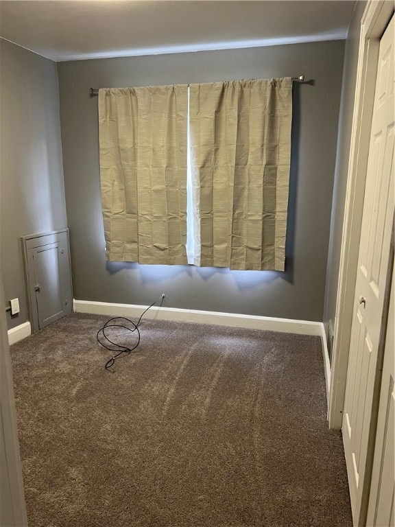 unfurnished room with dark carpet