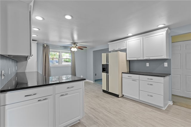 kitchen with light wood-type flooring, white refrigerator with ice dispenser, white cabinetry, kitchen peninsula, and ceiling fan