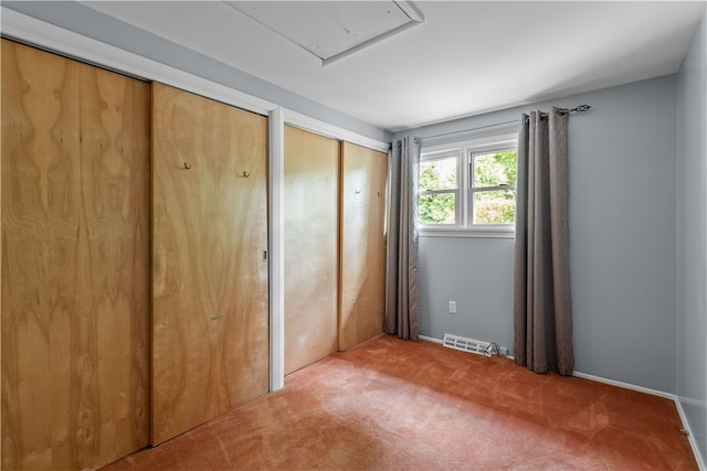 unfurnished bedroom featuring carpet floors and multiple closets