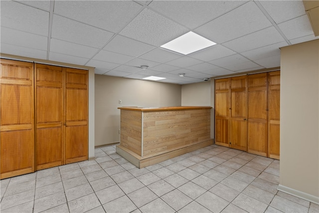 kitchen featuring a paneled ceiling and light tile patterned floors