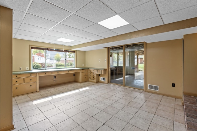 tiled empty room with a drop ceiling