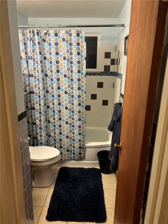 bathroom featuring tile patterned flooring, shower / bath combo, and toilet