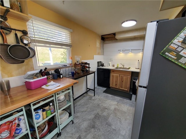 kitchen featuring sink, decorative backsplash, black dishwasher, white fridge, and butcher block counters