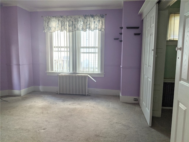 interior space featuring light carpet and radiator heating unit