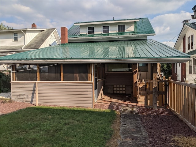 view of front of home with a sunroom and a front lawn