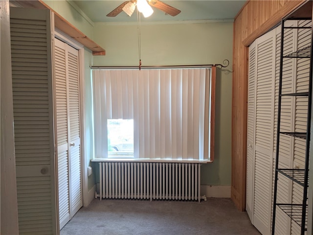 unfurnished bedroom with carpet floors, radiator, a closet, and ornamental molding