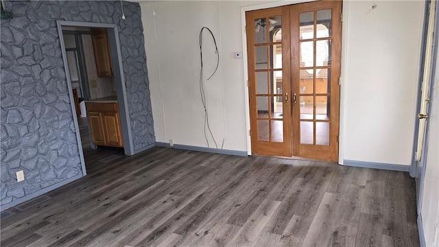 spare room featuring french doors, baseboards, and dark wood-style floors