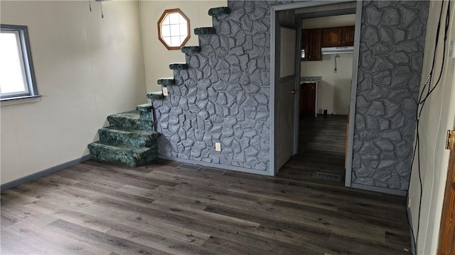 interior space featuring baseboards, stairs, and dark wood-style flooring