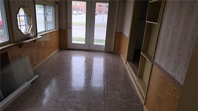 interior space with wood walls, a wainscoted wall, and wallpapered walls
