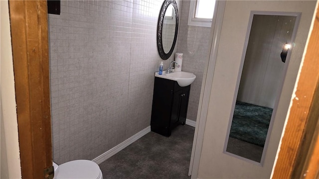 bathroom with toilet, vanity, and baseboards