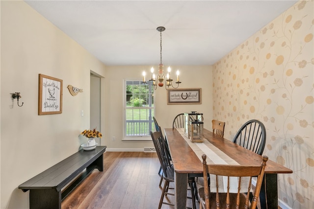 dining room with dark wood-type flooring and a notable chandelier