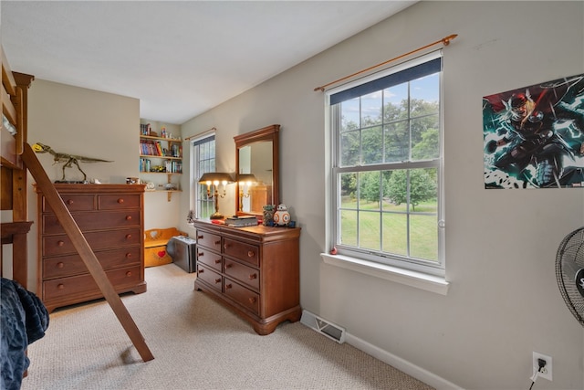 bedroom with multiple windows and light carpet