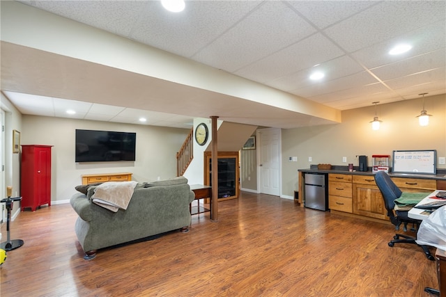 office featuring a paneled ceiling and dark wood-type flooring