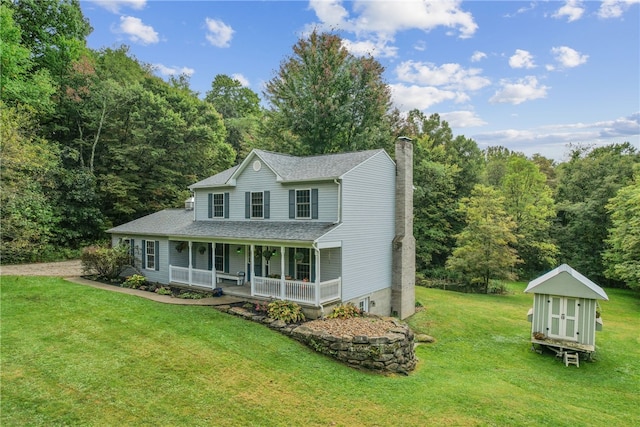 view of front of home with a storage shed, a porch, and a front yard