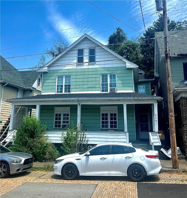 american foursquare style home featuring covered porch