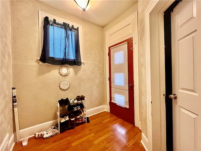 doorway to outside with hardwood / wood-style floors and a textured ceiling