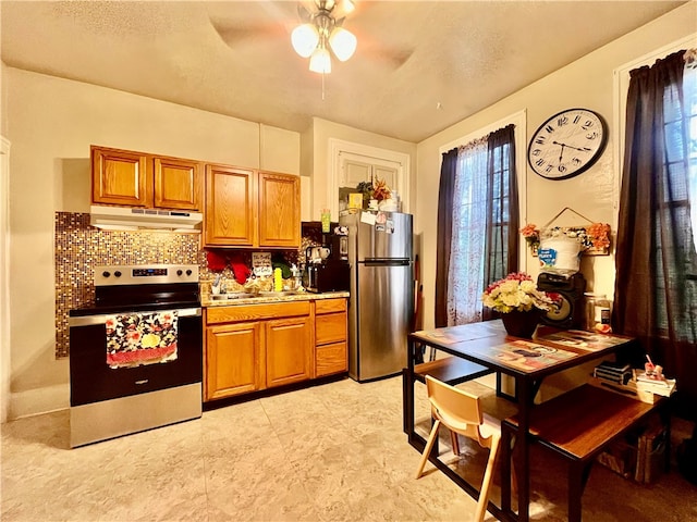 kitchen featuring decorative backsplash, stainless steel appliances, plenty of natural light, and ceiling fan