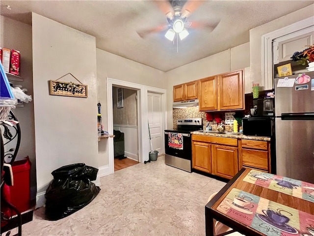 kitchen with ceiling fan, sink, stainless steel appliances, and a textured ceiling