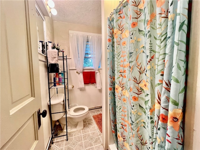 bathroom featuring a shower with shower curtain, tile patterned flooring, toilet, and a textured ceiling