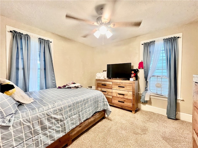 carpeted bedroom with ceiling fan and a textured ceiling